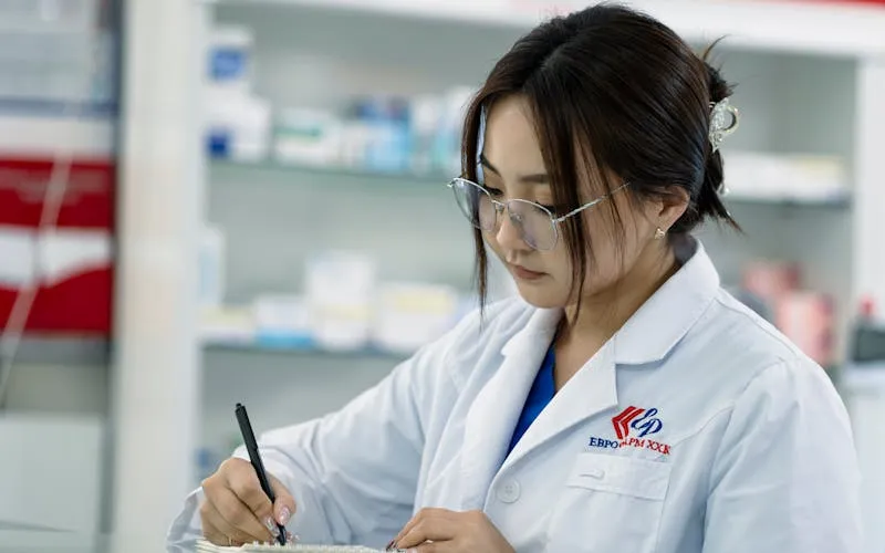 Pharmacienne prenant des notes pour le document unique d'évaluation des risques en officine